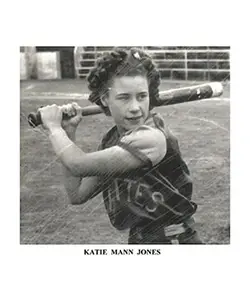 A young girl holding a baseball bat on top of a field.