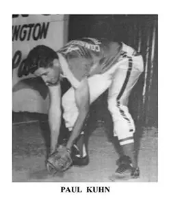 A man kneeling down in front of a baseball glove.