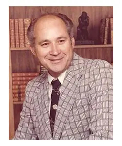 A man in a suit and tie smiling for the camera.