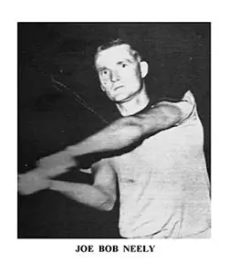 A man swinging a baseball bat in front of the camera.