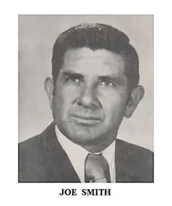 A black and white photo of an older man wearing a suit.