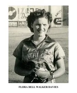 A woman standing in front of a building holding a camera.