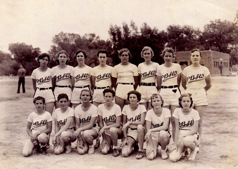 A group of women in baseball uniforms posing for a picture.