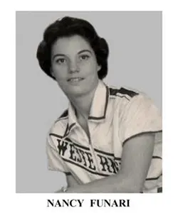 A woman in a white shirt is posing for the camera.