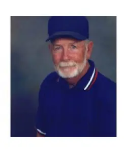 A man with white beard wearing blue shirt and hat.