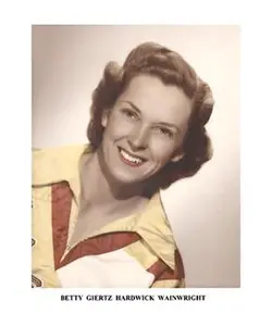 A woman in yellow and red shirt smiling for the camera.