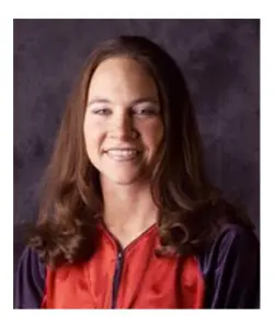 A woman with long hair is smiling for the camera.