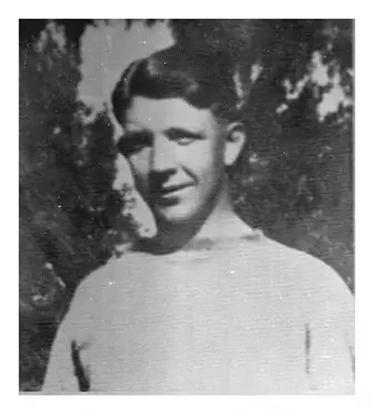 A young man in white shirt and black hat.