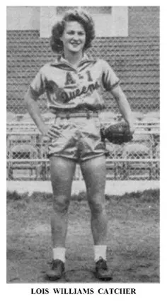 A man in shorts and baseball uniform holding a ball.