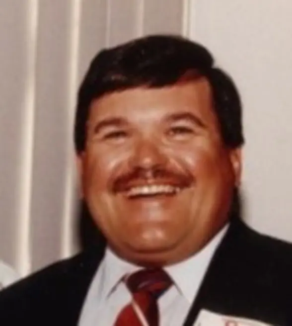 A man with a mustache and suit jacket.